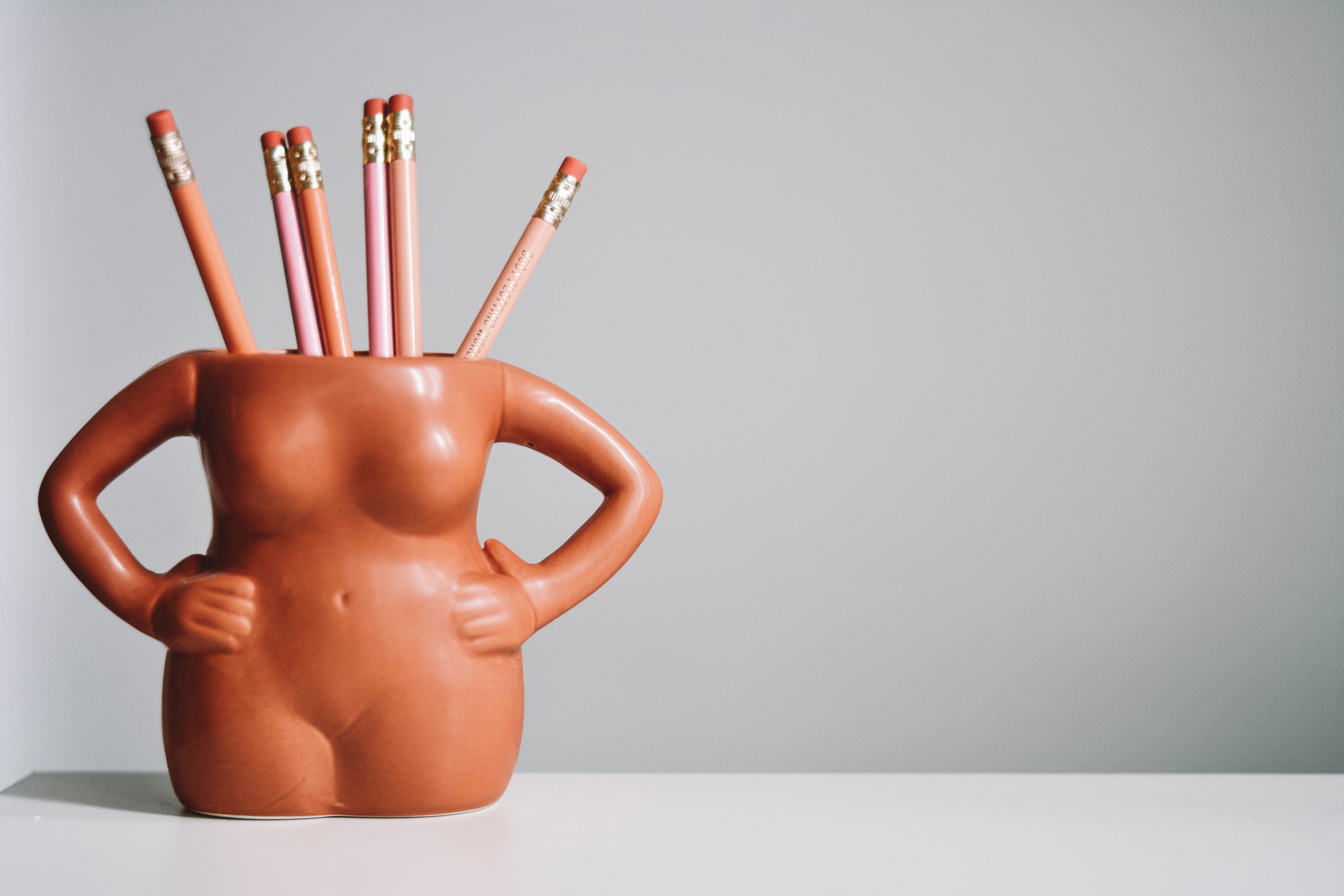 brown ceramic mug with pencils